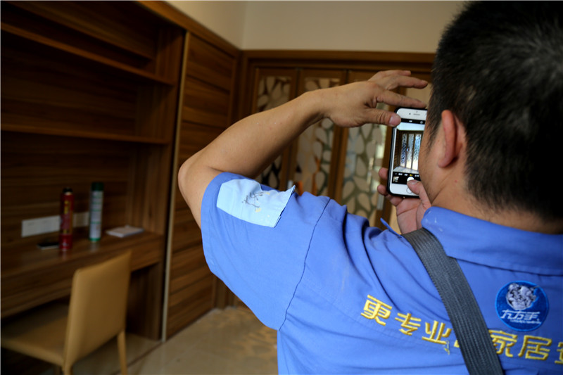 謝師傅看著安裝好的家具，拍下照片